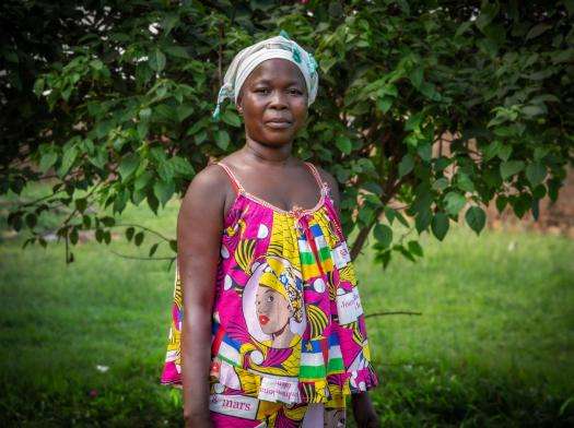 Woman in a pink printed dress standing on grass in Central African Republic