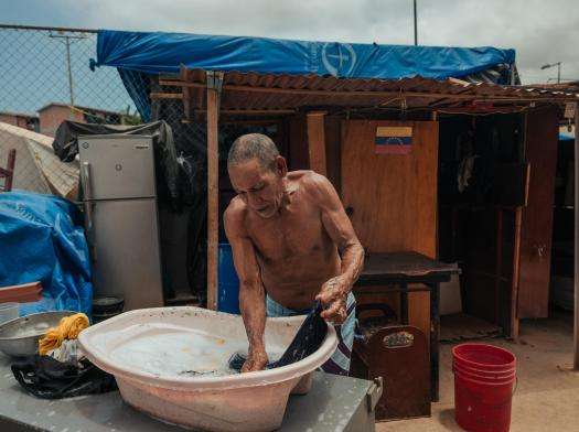 Hector Garcia, 75, washes his clothes in an encampment set up outside a housing complex that partially collapsed during the twin earthquakes in Venezuela.
