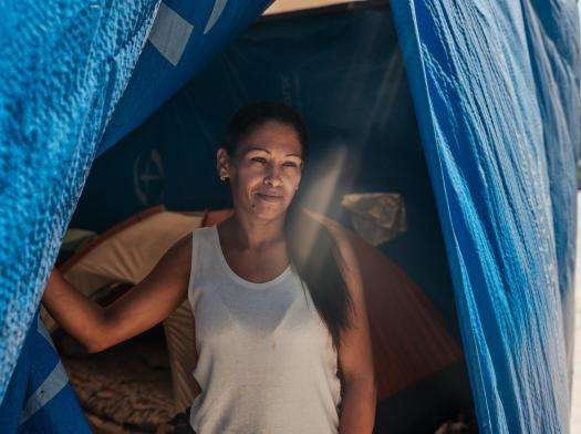 Sheryl Manrique, 43, stands outside her tent in an encampment on Avenida Bolívar, set up outside a housing complex that was evacuated after the twin earthquakes in Venezuela.