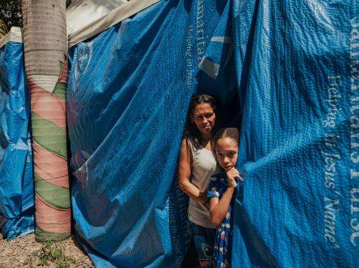 A displaced mother and child in a tent in Venezuela.
