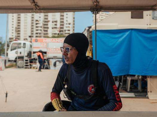 Elvis Diaz, 28, a member of the Venezuelan Civil Protection, sits in a tent in Playa Grande, next to a housing complex that collapsed during the twin earthquakes in Venezuela.