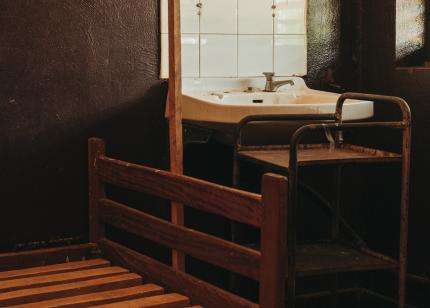 Bare wooden hospital bed and sink at Bakouma secondary hospital in Central African Republic.