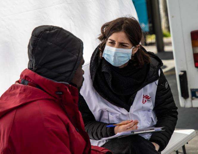 MSF nurse Charline Vincent consults with a patient during a mobile clinic at Porte de la Villette, France.