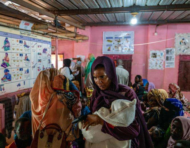Families wait inside El Geneina Teaching Hospital, one of the few public hospitals still functioning in West Darfur, Sudan.