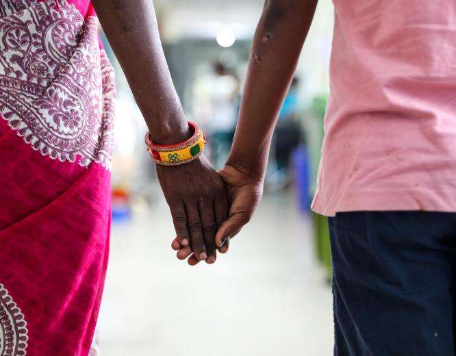 Nisha*, an advanced HIV survivor, and her daughter hold hands and walk through the corridor of MSF’s advanced HIV care centre at Guru Gobind Singh Hospital, Patna, Bihar
