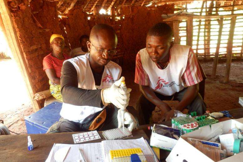 Lab technicians, who are part of a mobile HAT Team in the Democratic Republic of Congo, execute the second step of a test for sleeping sickness.  