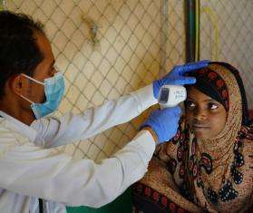 MSF nurse Yaseem checks the temperature of a patient