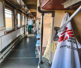 White cloth with MSF logo hangs inside the MSF medical evacuation train in Ukraine.