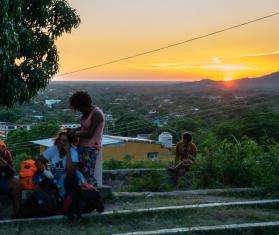 Migrants resting on a hilltop at sunset in Arriaga, Chiapas, Mexico