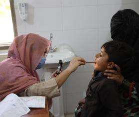 A doctor performs a checkup of a child in Pakistan. 