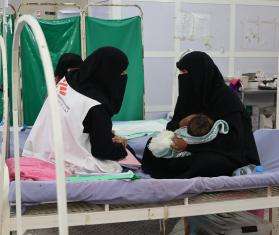 A social worker speaks with a mother in a hospital in Yemen. 