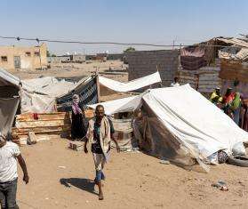 People walk in a displacement camp in Yemen. 