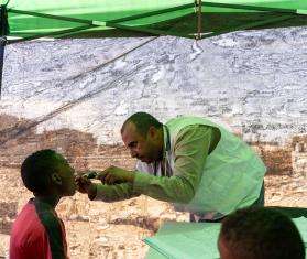 A health care worker examines a boy in Yemen. 