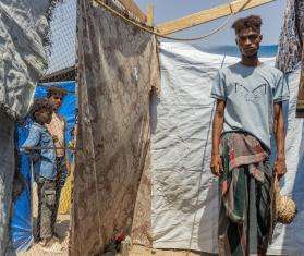 A displaced man in front of a tent in Yemen.