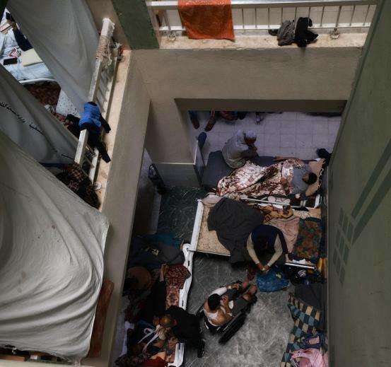 Crowded stairwell inside Al-Aqsa Hospital in Gaza.