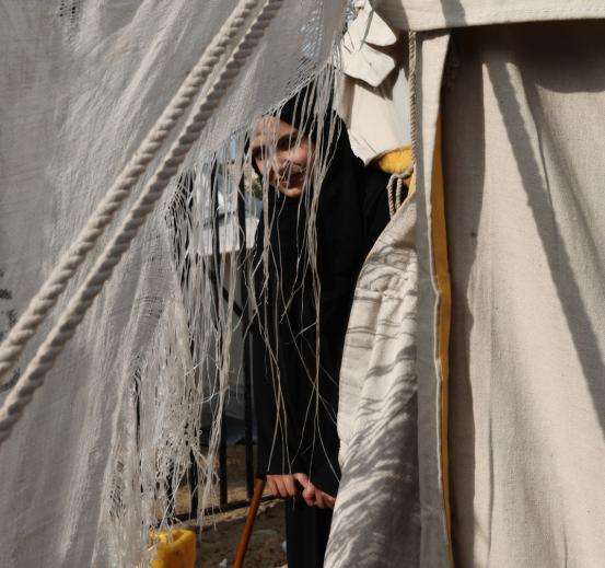 A Palestinian woman looks through her tent in Gaza.