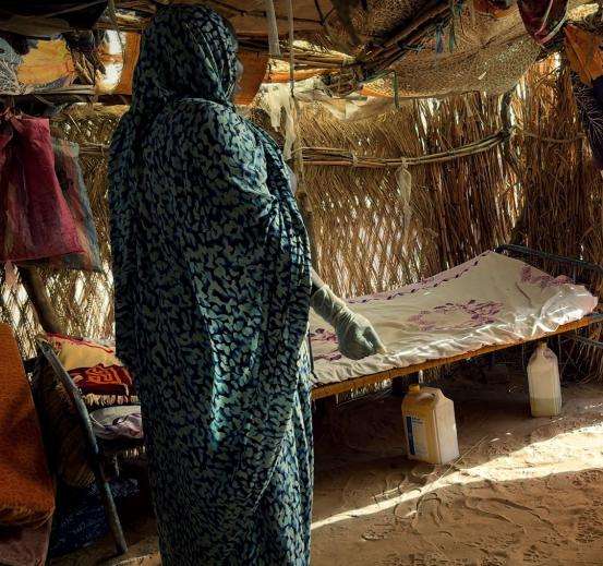 Khadija has set up a simple but tidy bed and consultation area in her shelter of woven twigs and branches where she lives with her children.