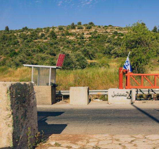 A checkpoint in Ramallah, Palestine, with threatening graffiti saying, "There is no future."