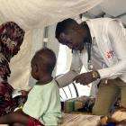 A doctor examines a young boy in Sudan. 