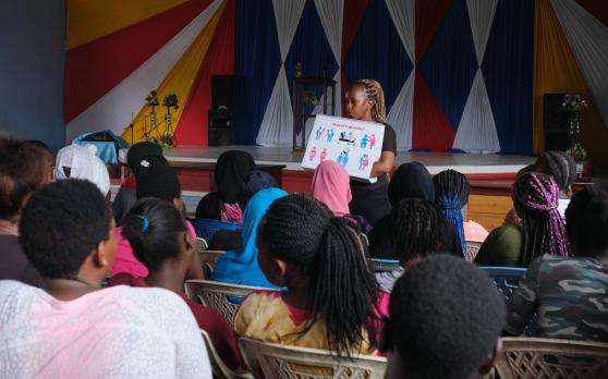 A peer talks to a group of teenagers about sex education at a church for outreach activities in Kenya.